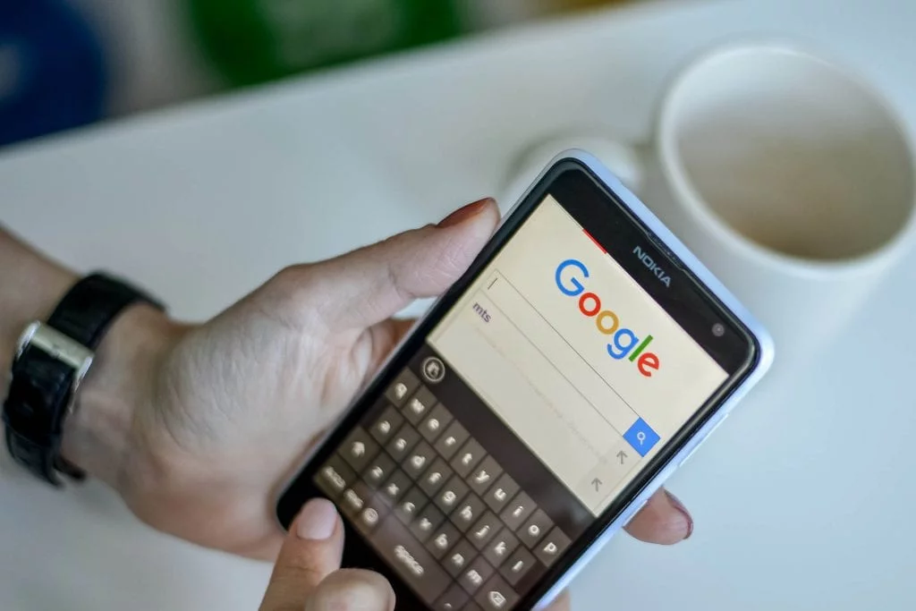 Someone using a mobile phone to search Google
